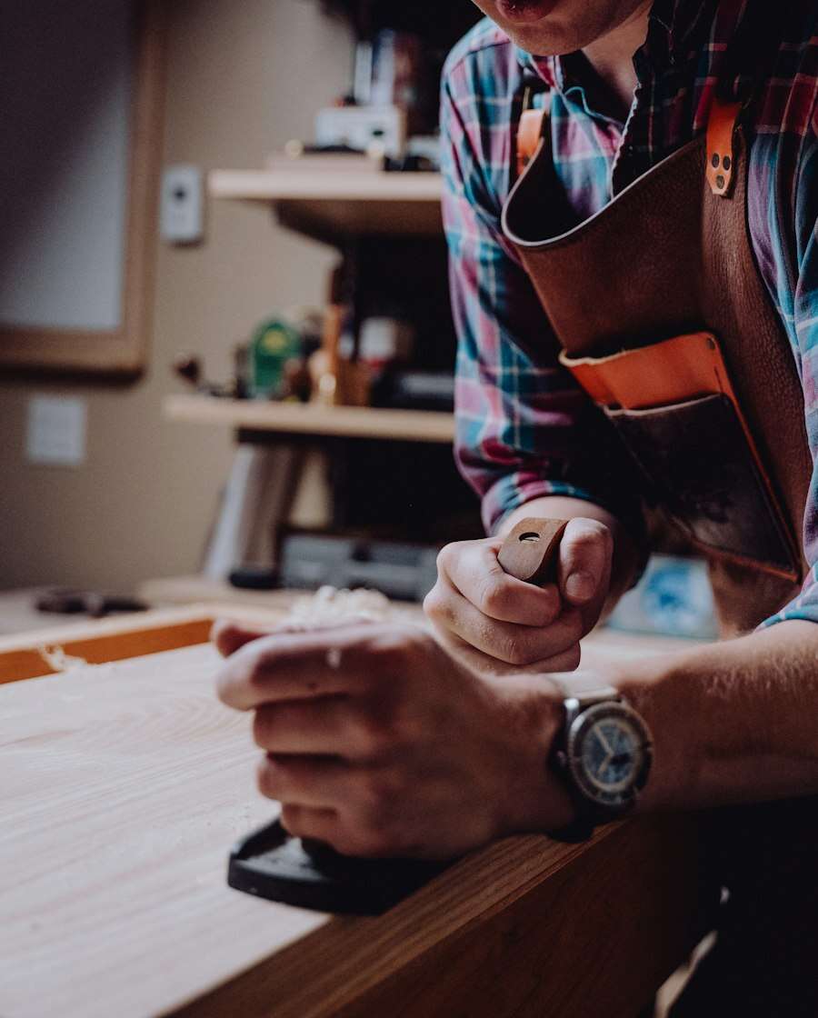 Mains d’un artisan travaillant le bois
