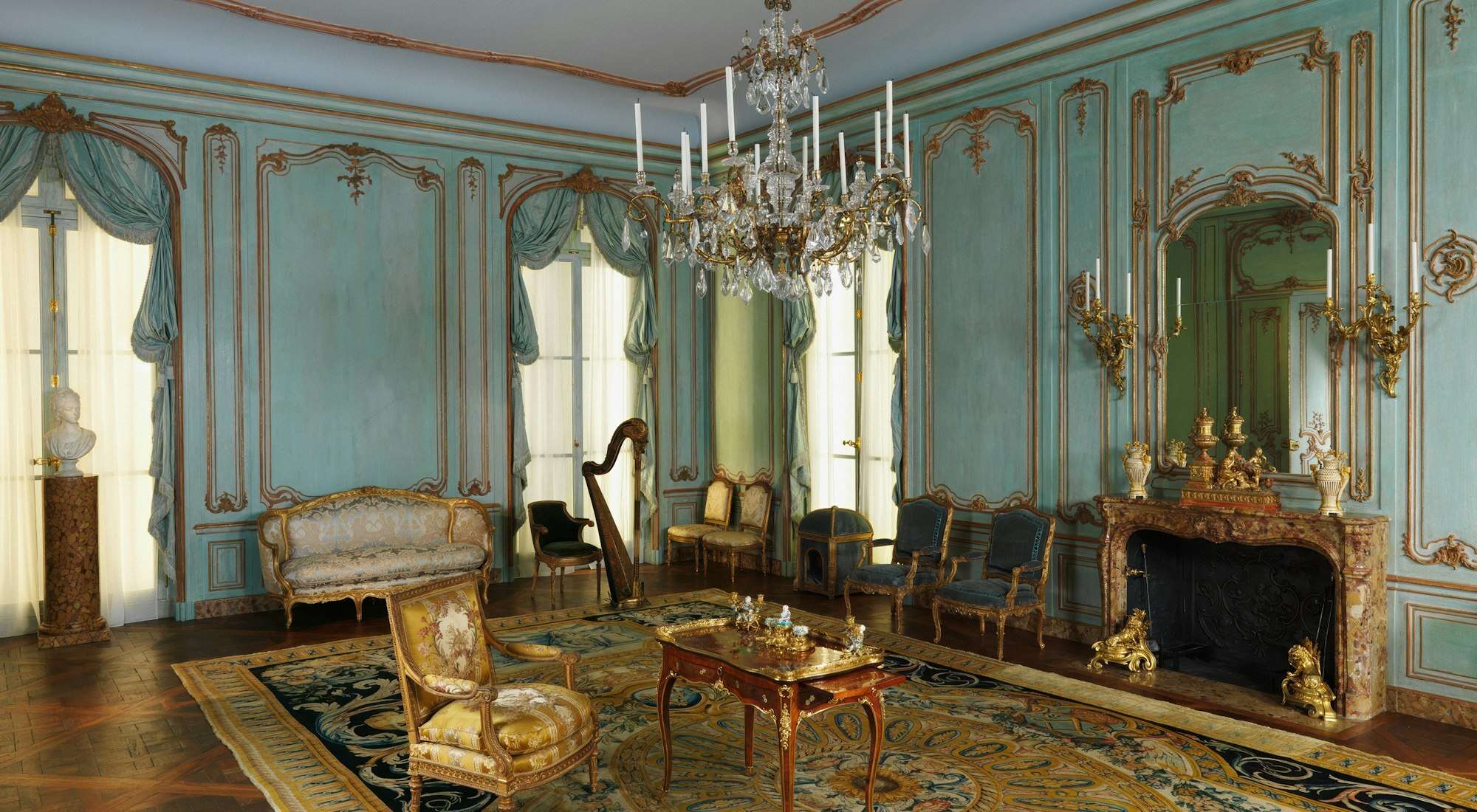 Salon à boiseries, lustre et cheminée